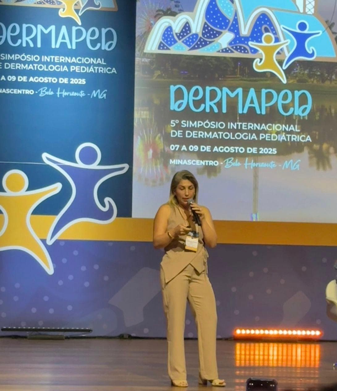 Dra. Karimy Mehanna palestrando no palco do 5º DERMAPED, Simpósio Internacional de Dermatologia Pediátrica, em Belo Horizonte